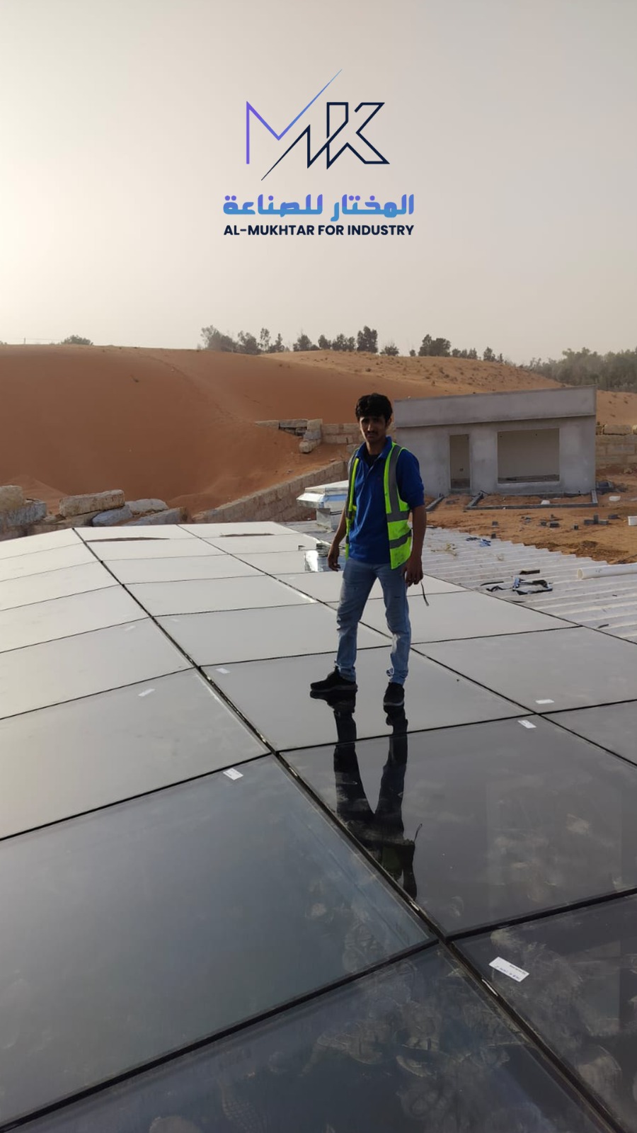فني يقف على سقف زجاجي أثناء التركيب